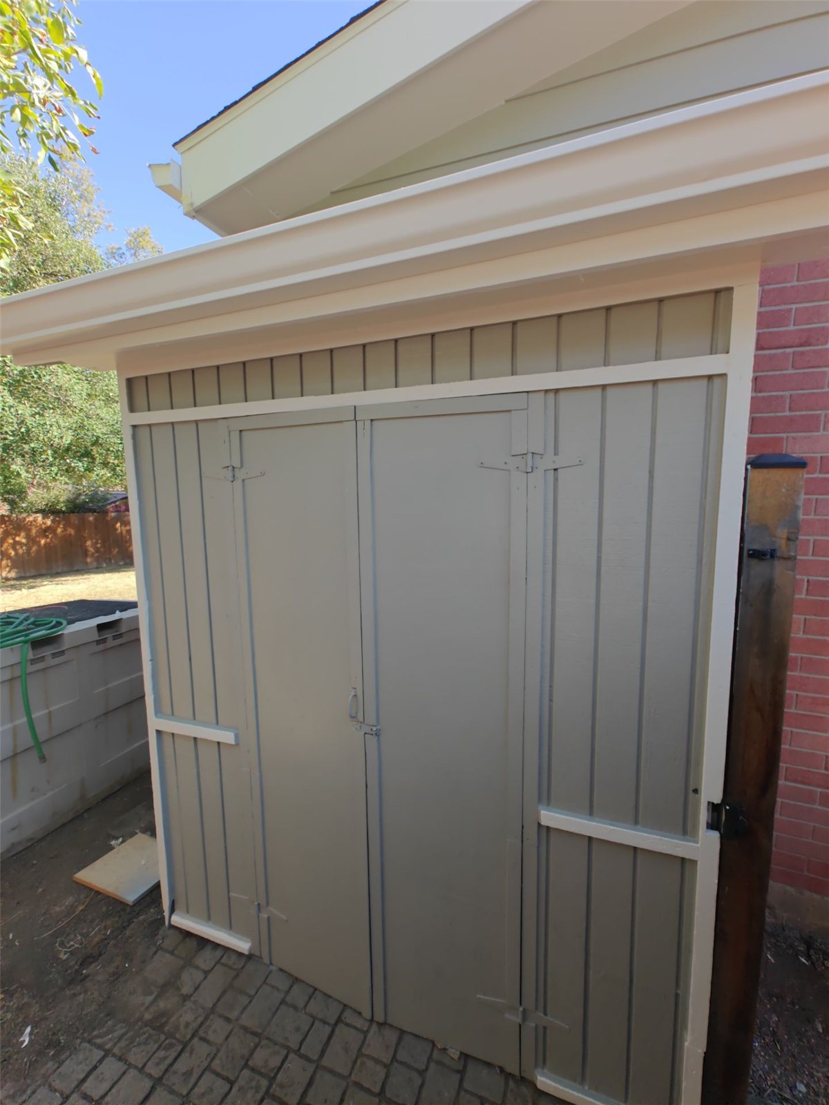 After: matching detached storage shed repainted to coordinate with the house