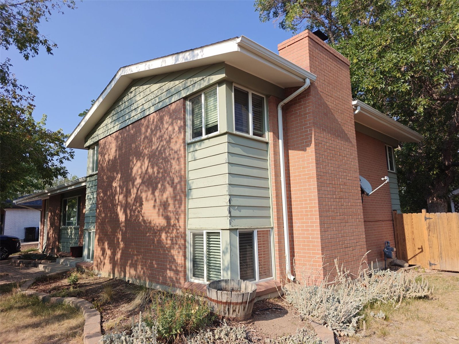 Before: the original faded sage-green siding on the Arvada home